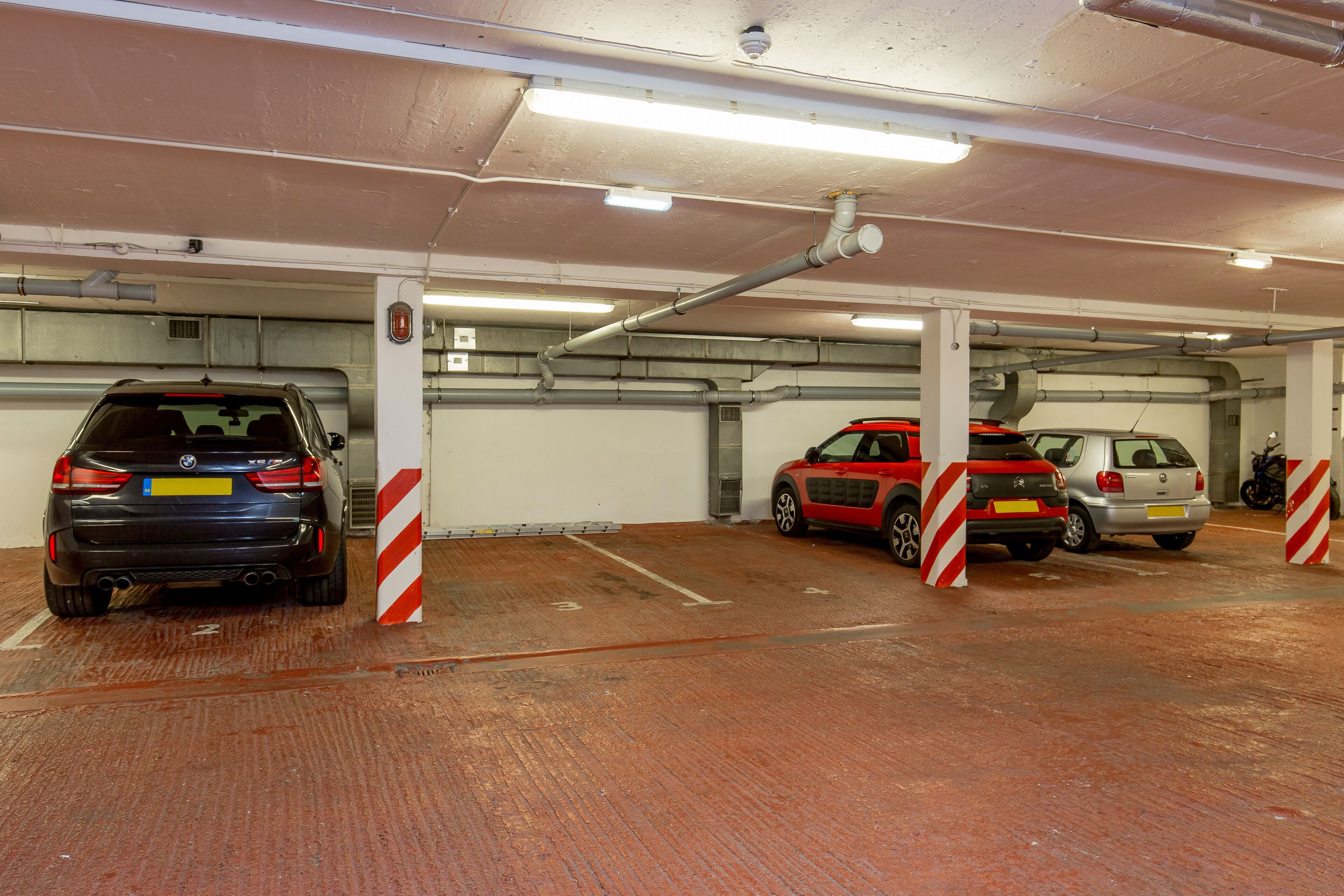 A multi-level underground parking garage with cars parked in designated spaces.
