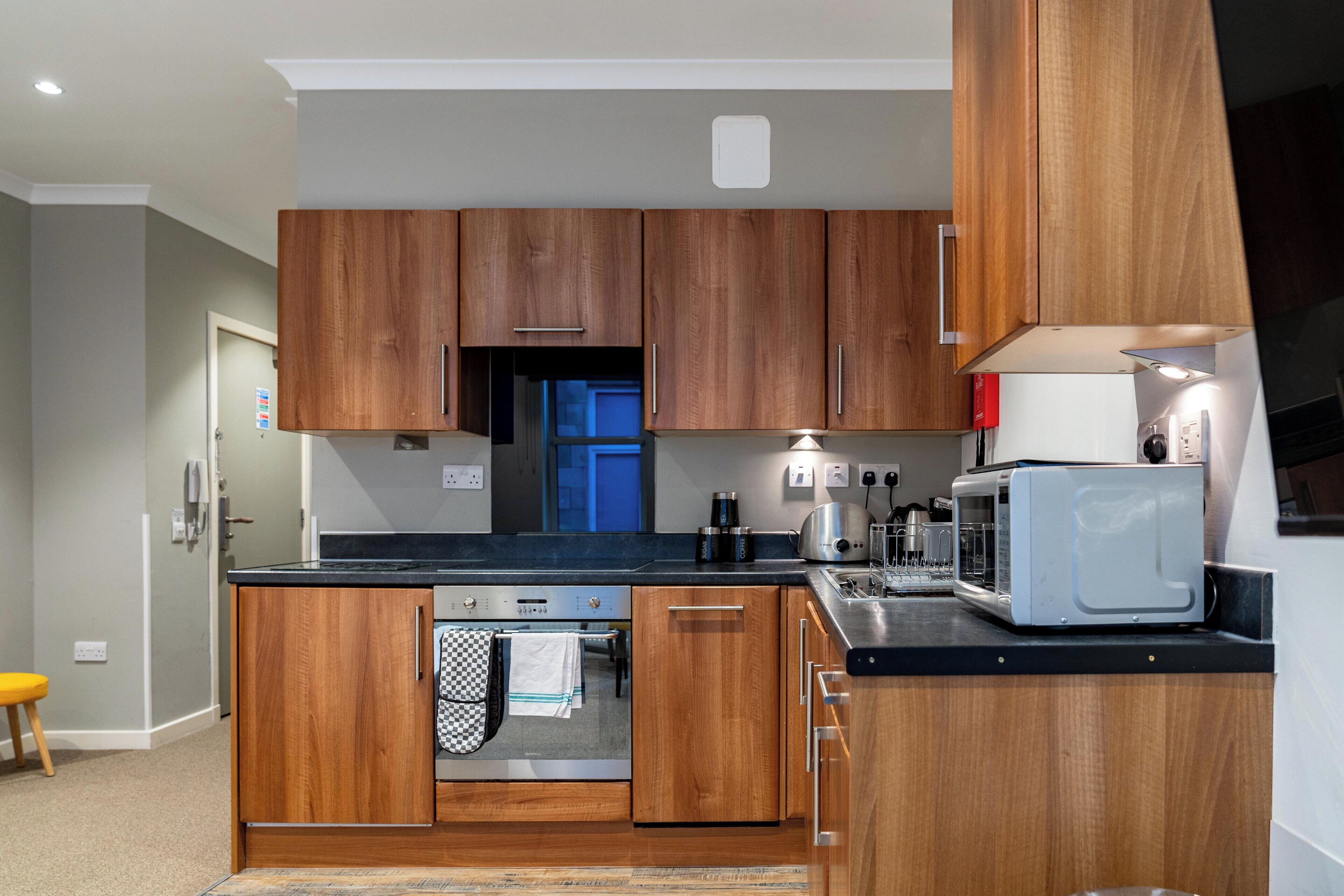 Une cuisine moderne avec des meubles en bois, un four à micro-ondes et un grille-pain.