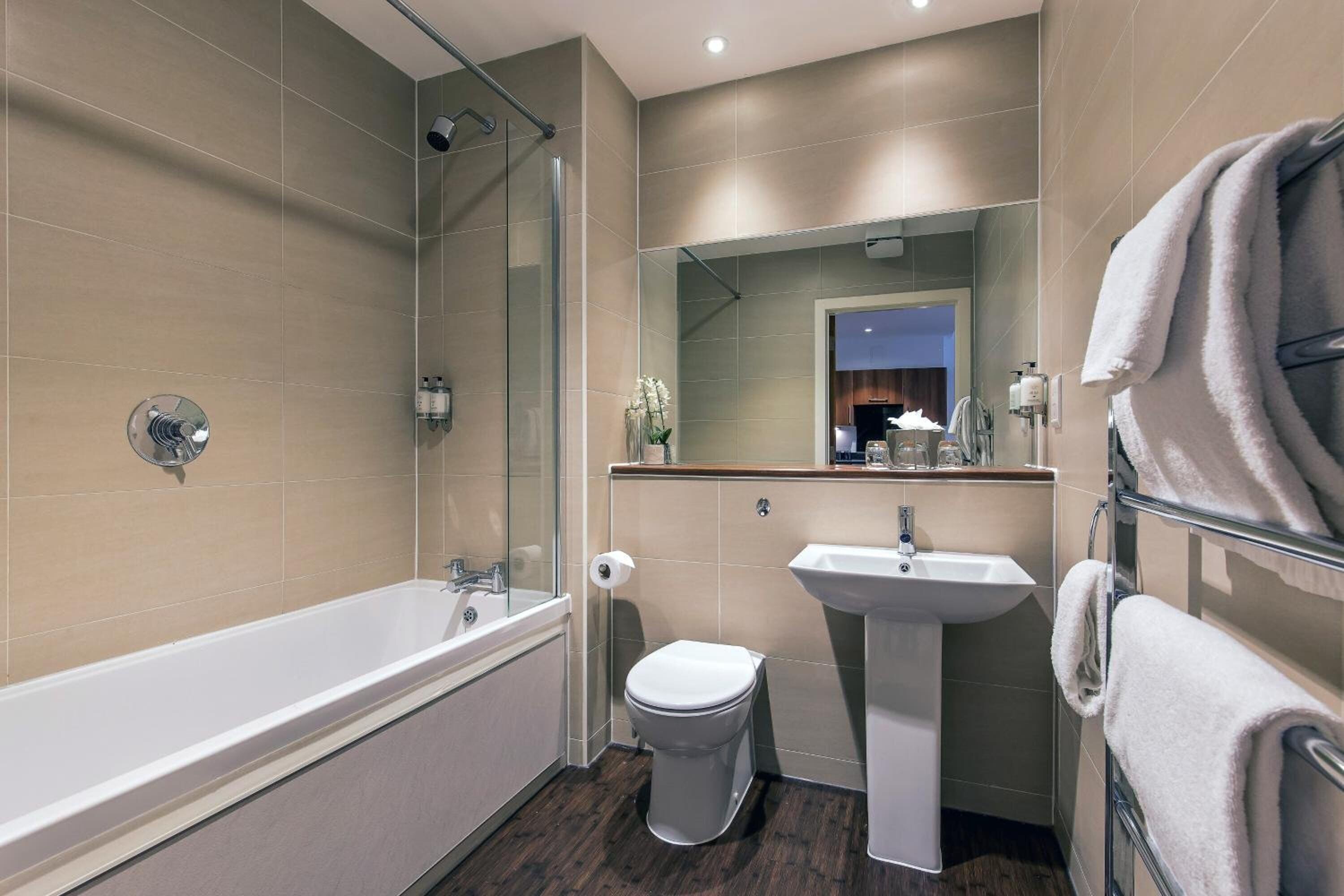 Un bagno moderno con vasca, servizi igienici e lavandino.