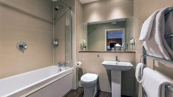 A modern bathroom with a bathtub, toilet, and sink.