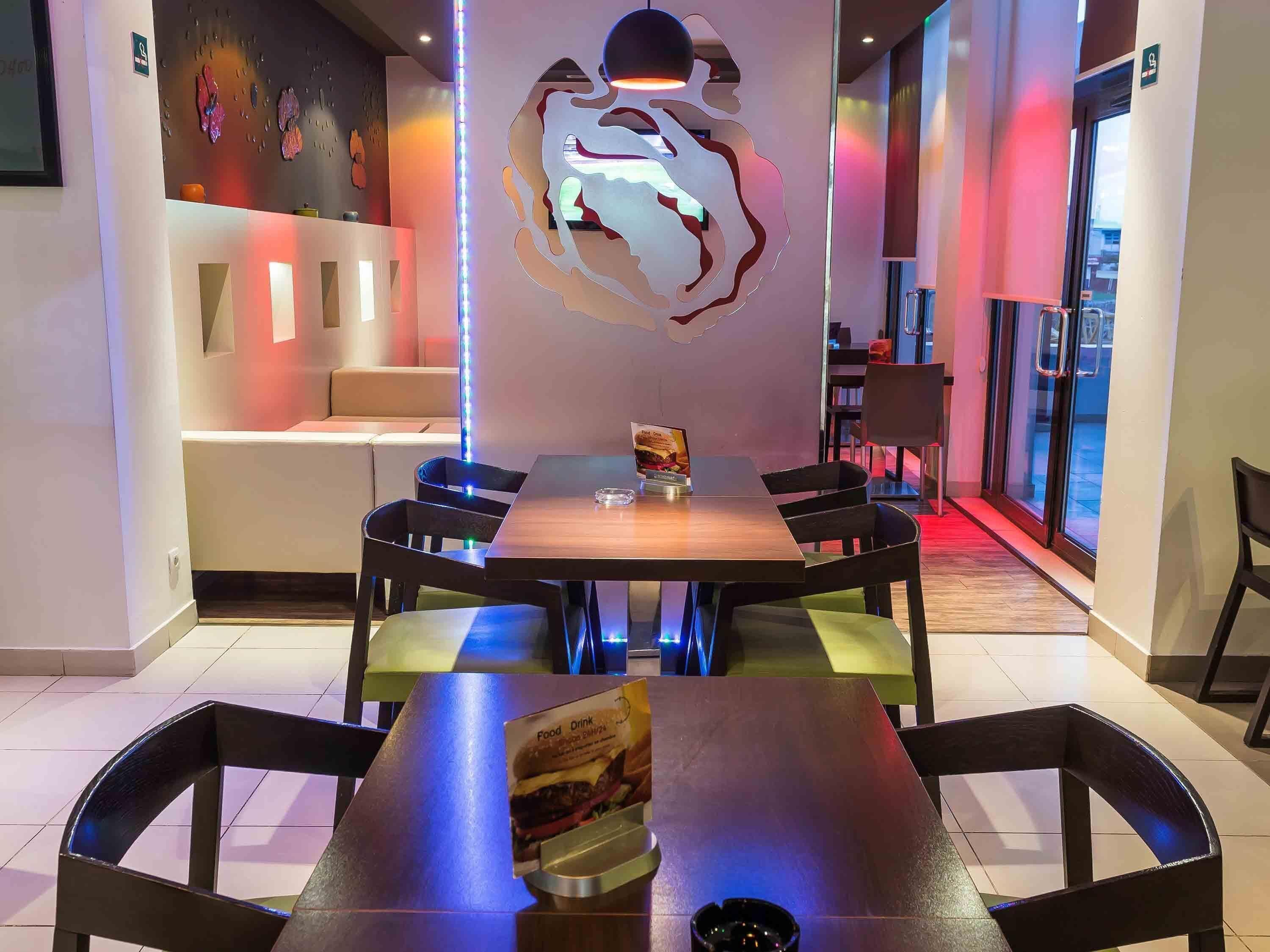 A modern dining area with a central table, chairs, and a unique wall art piece.