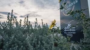 Een bord voor Blanco River Hotel en Hill Country Tavern, met een logo en tekst.