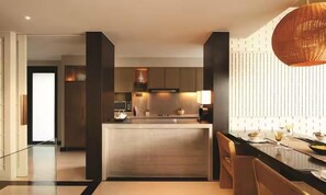 A modern kitchen with a central island, built-in appliances, and a dining area with a table and chairs. - Conrad Koh Samui (Koh Samui)