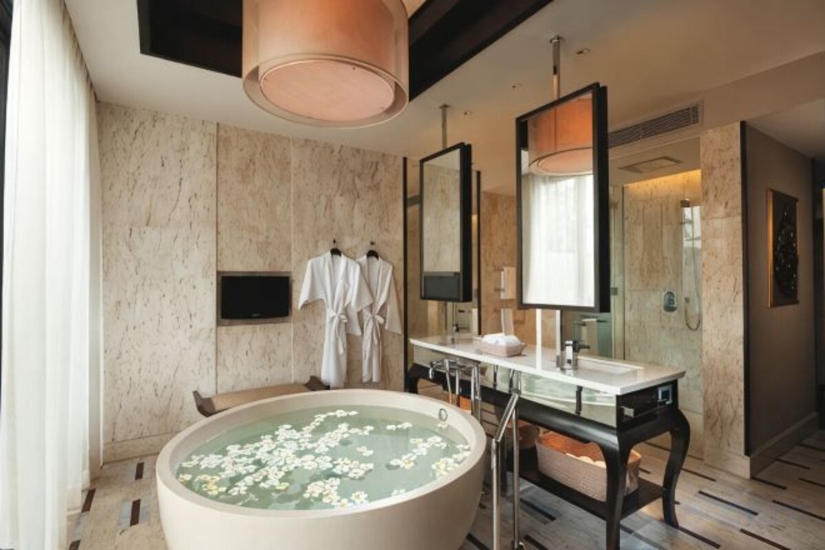 A modern bathroom with a large bathtub, a vanity with a mirror, and a shower area.