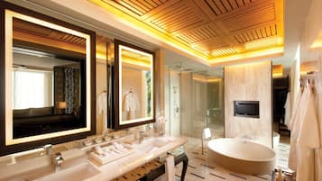 A modern bathroom with a large vanity, a freestanding bathtub, and a large mirror.