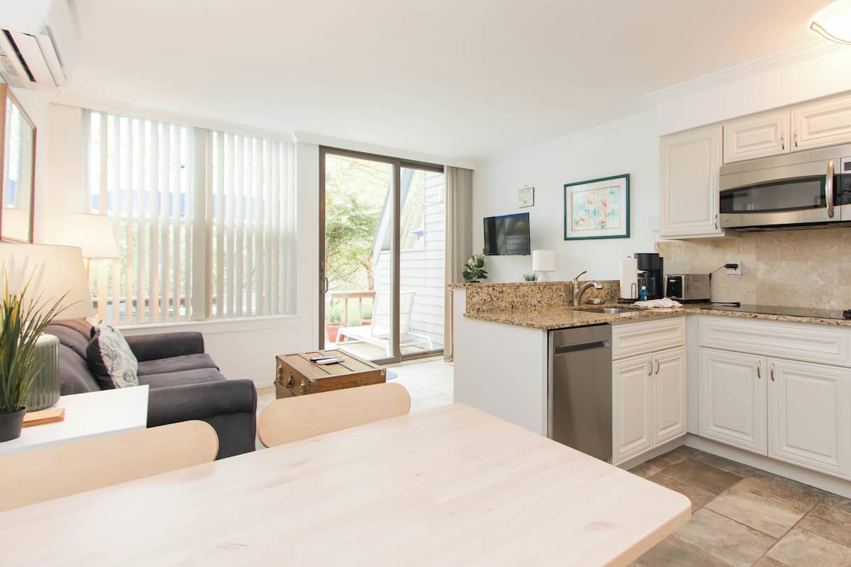 A modern kitchen with white cabinets, a stainless steel microwave, and a dishwasher.