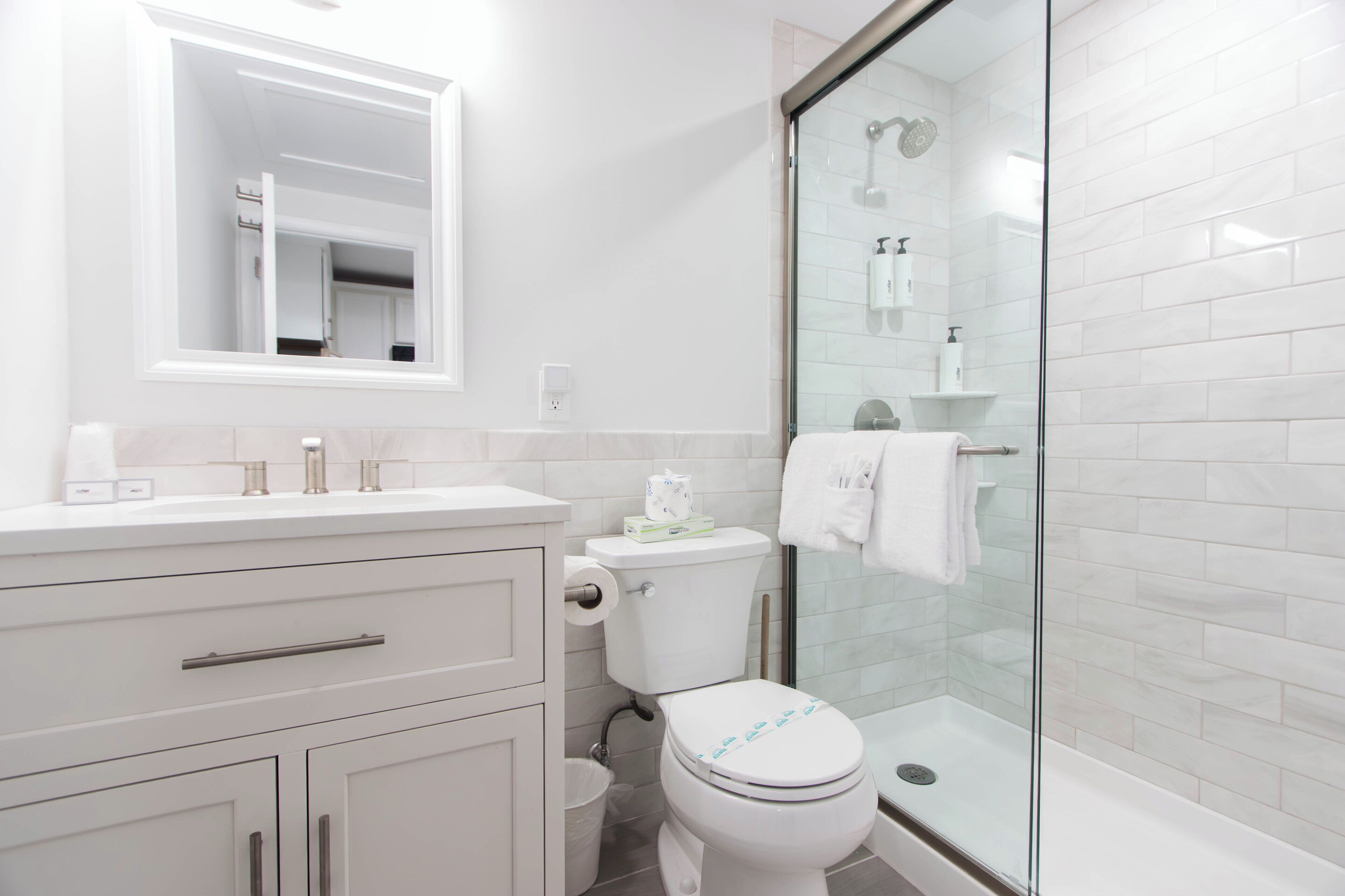 A modern bathroom with a toilet, sink, and shower.