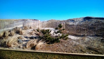 Na praia, espreguiçadeiras, guarda-sóis, toalhas de praia