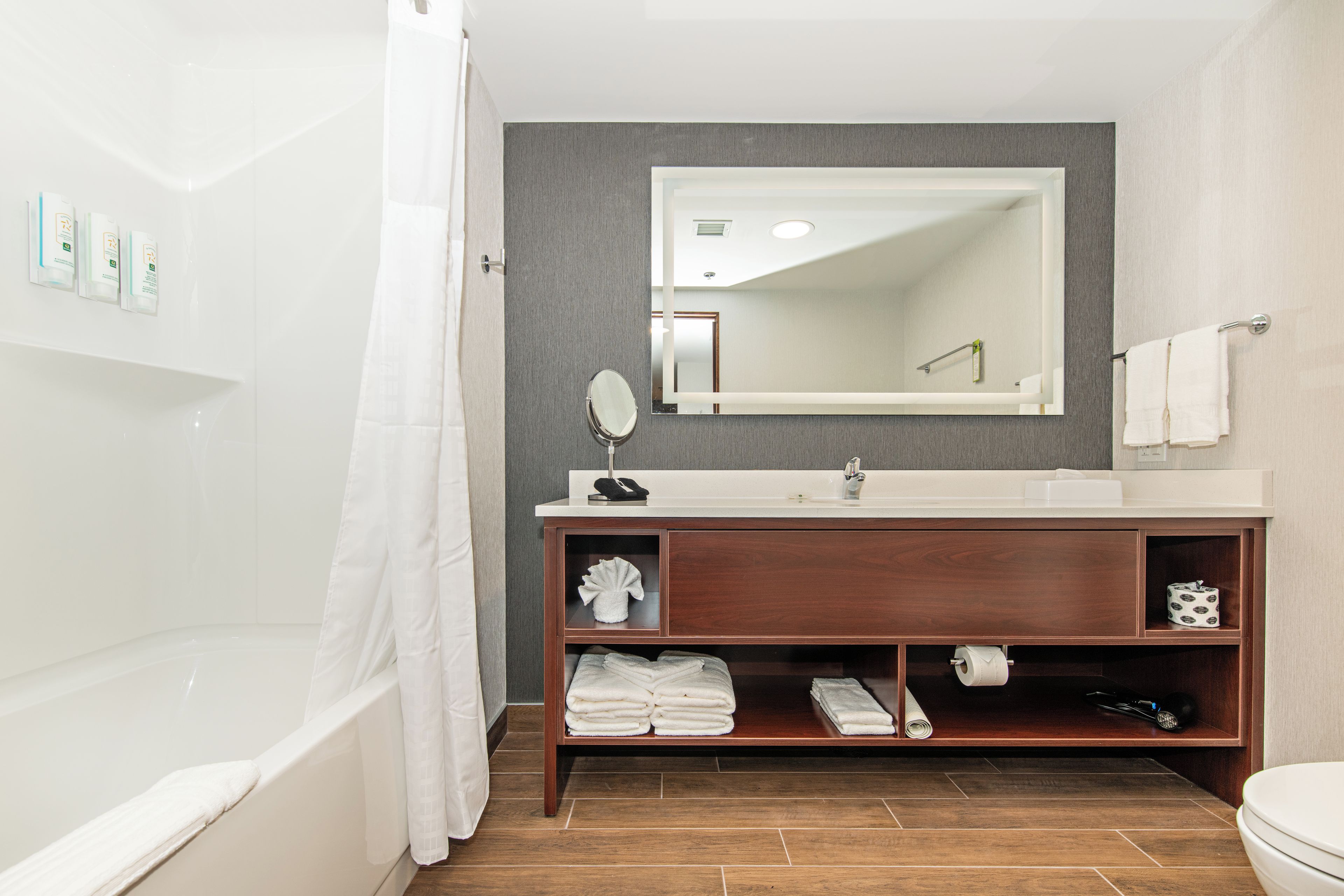 A bathroom with a bathtub, a sink, a mirror, and a shower curtain.