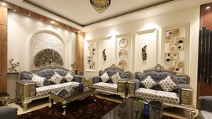 A luxurious living room with ornate sofas, a large chandelier, and decorative wall art. - Days Hotel by Wyndham Neemrana Jaipur Highway (Neemrana)