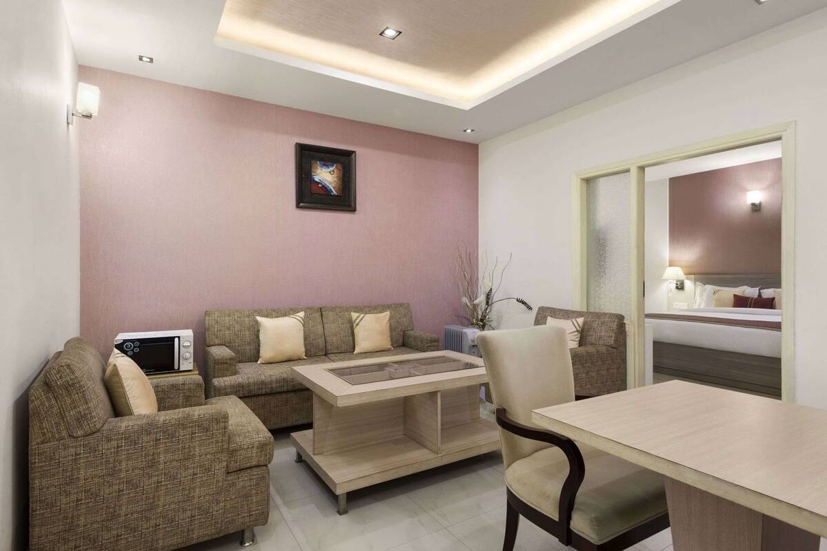 A modern living room with a sofa set, a coffee table, and a dining table.