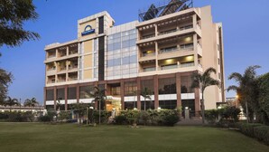 A hotel with multiple floors, a prominent Days Hotel sign, and a well-maintained lawn area. - Days Hotel by Wyndham Neemrana Jaipur Highway (Neemrana)