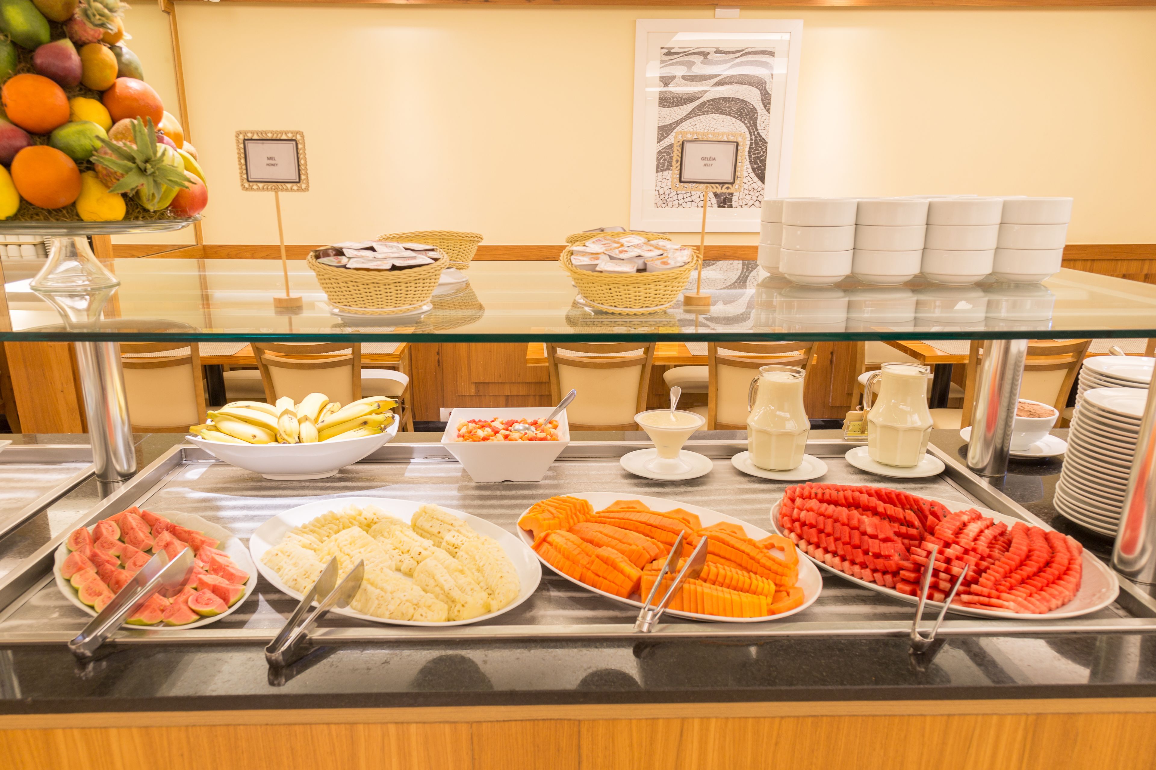 Un bufé con diversas opciones de comida, como frutas, ensaladas y postres.