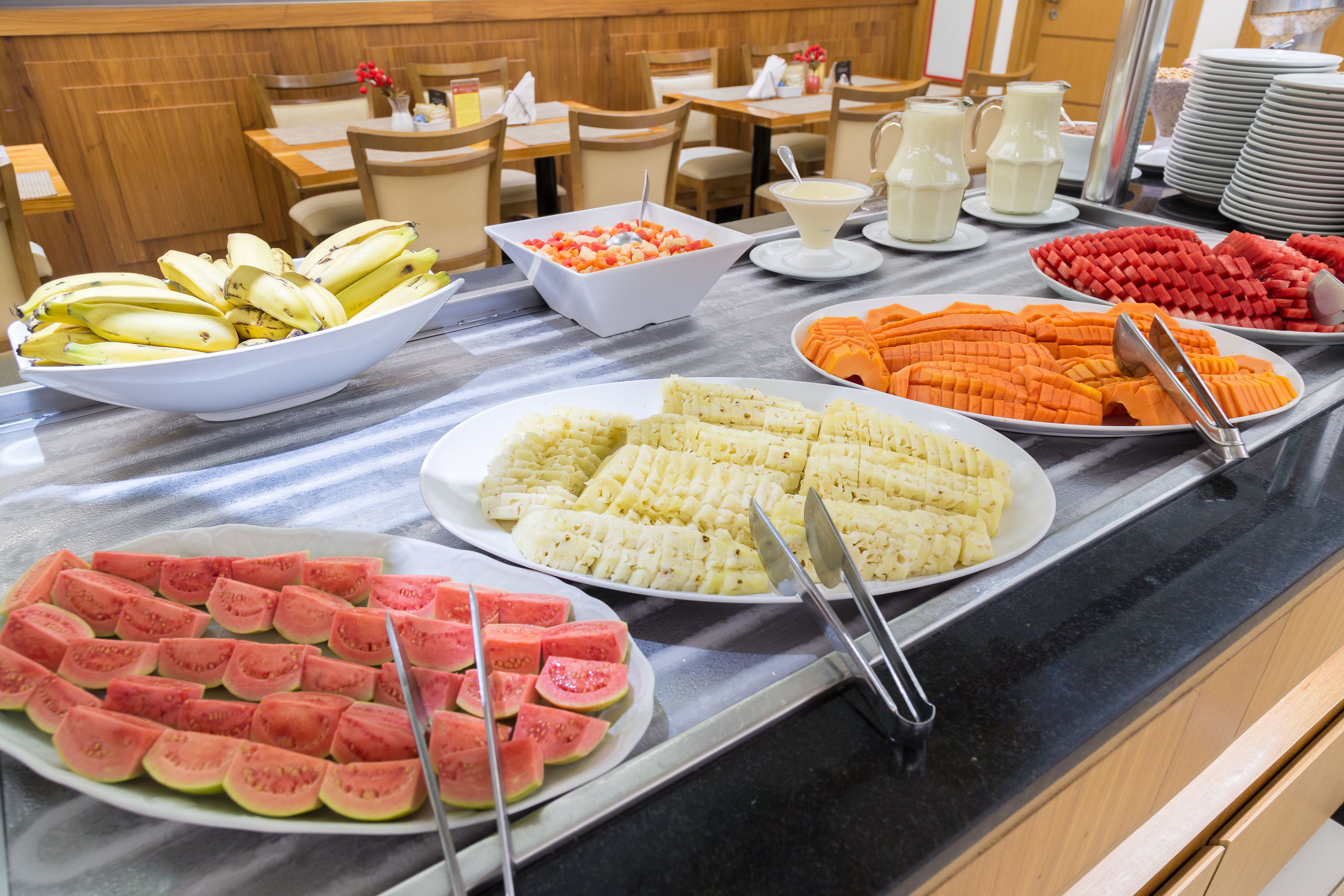 A buffet with various fruits and vegetables, including watermelon, corn, and carrots.