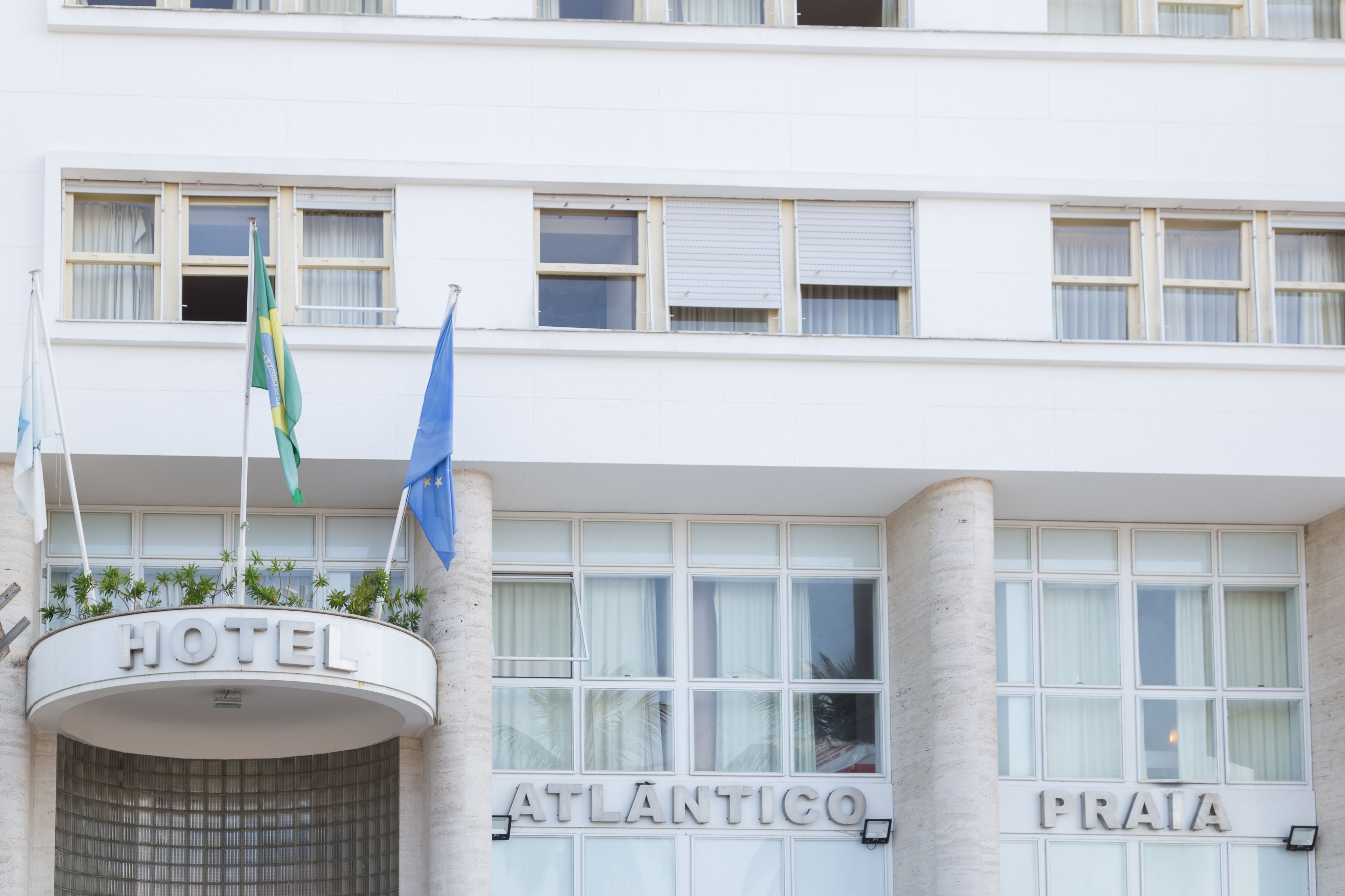 L’entrée d’un hôtel, avec une enseigne indiquant « HÔTEL ATLANTICO PRAIA ».