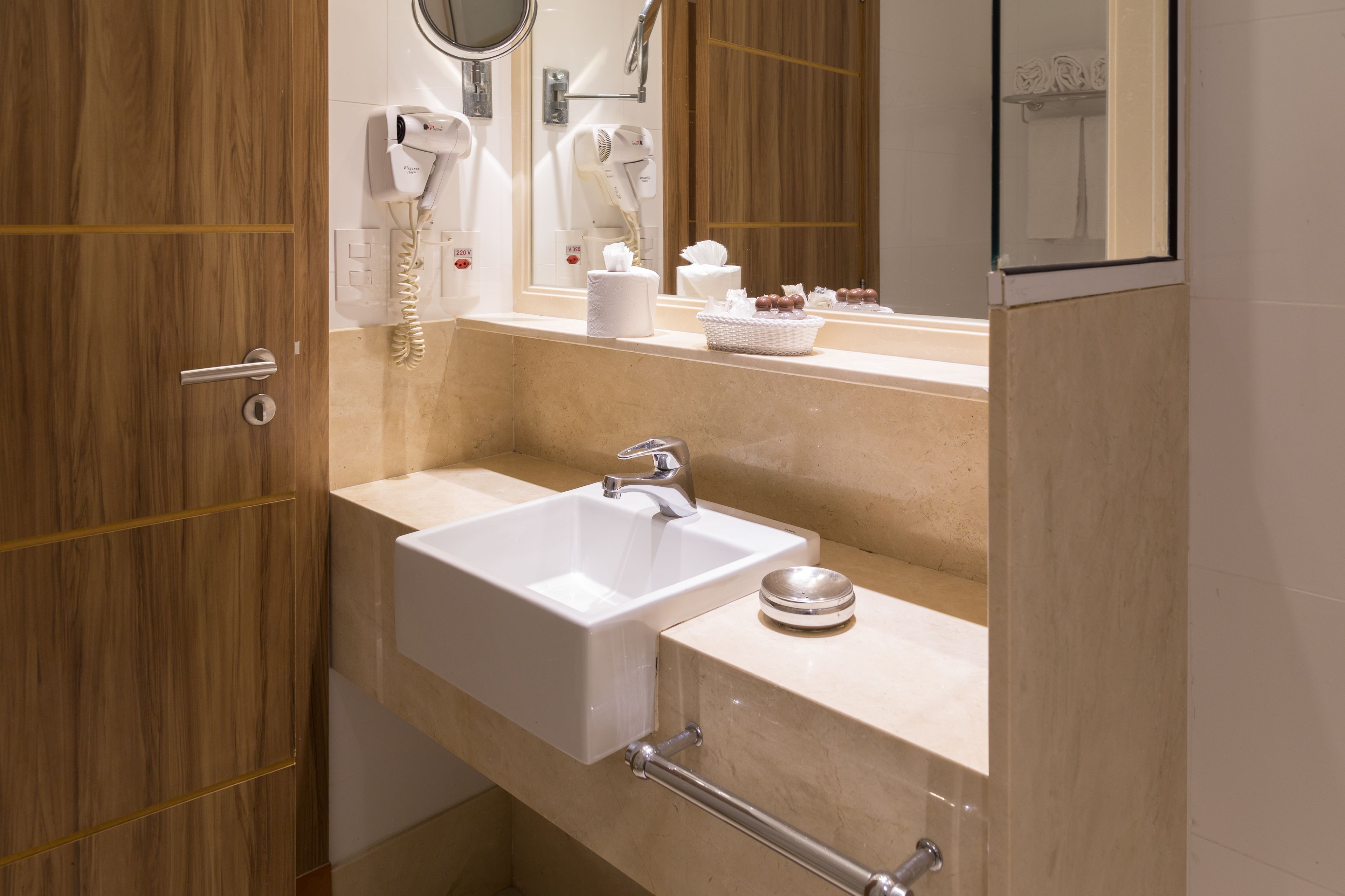 A bathroom with a sink, mirror, and hairdryer.
