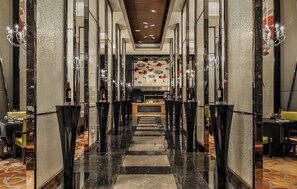 A hotel corridor with a central bar area, mirrored walls, and a patterned floor. - Intercontinental Wuxi by IHG (Wuxi)