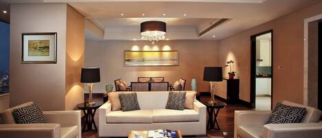 A modern living room with a sofa set, two side tables, a coffee table, and artwork on the walls.
