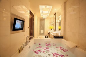 A modern bathroom with a large bathtub, a television mounted on the wall, and a mirror reflecting the room. - Intercontinental Wuxi by IHG (Wuxi)