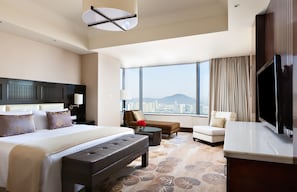 A spacious hotel room with a large bed, a sofa, a coffee table, and a TV. - Intercontinental Wuxi by IHG (Wuxi)