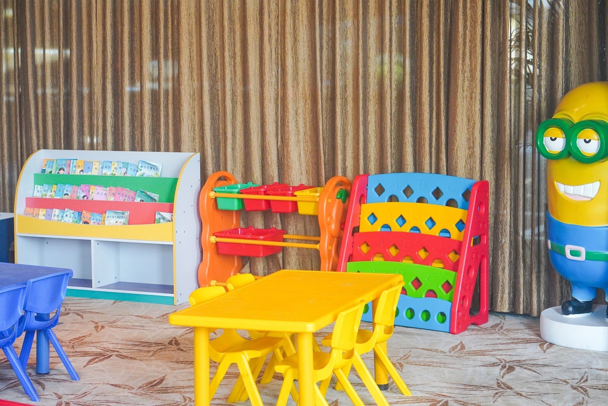 A children's play area with colorful play structures and a yellow table.
