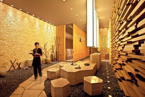 A modern interior with a reception desk, stone flooring, and wooden accents. - Intercontinental Wuxi by IHG (Wuxi)
