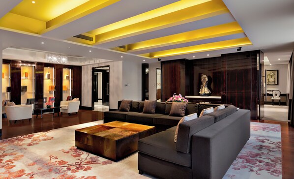 A modern living room with a sectional sofa, a coffee table, and a decorative rug. - Intercontinental Wuxi by IHG (Wuxi)
