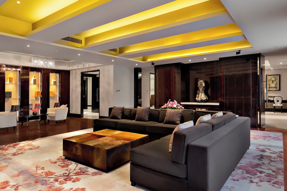 A modern living room with a sectional sofa, a coffee table, and a decorative rug.