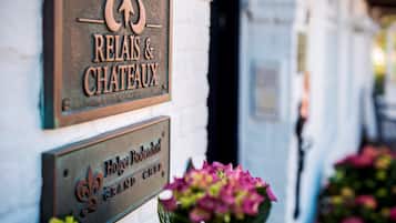 Een bord met 'Relais & Chateaux' en 'Hotel Bodendorfer Grand Hôtel', met een toekanmotief.