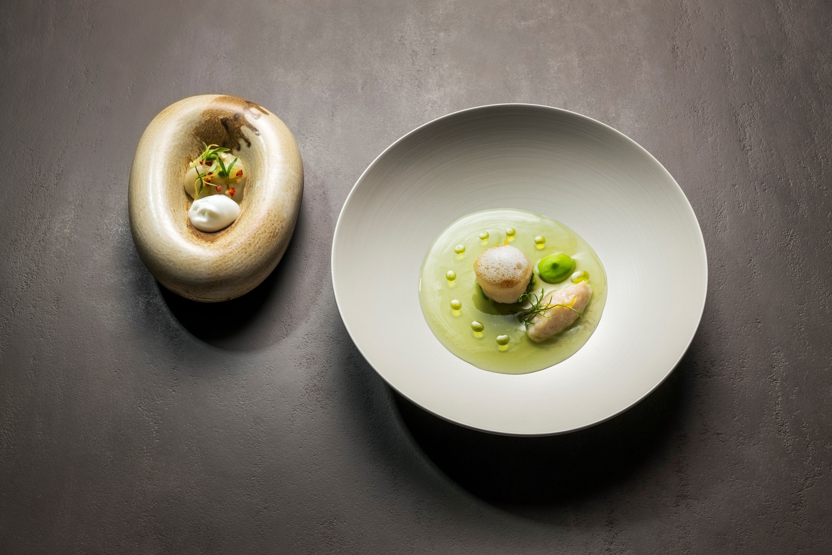 A modern dining table with two plates of food.