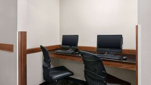 A small office space with two desks, each equipped with a computer and keyboard. - Travelodge by Wyndham McAlester (McAlester)
