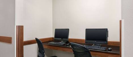 A small office space with two desks, each equipped with a computer and keyboard.