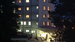 Ein mehrstöckiges Hotel mit beleuchteten Fenstern und einem hell erleuchteten Eingangsbereich.