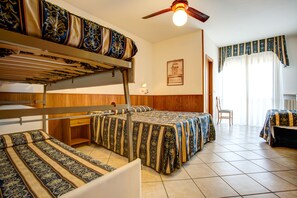 Una habitación con literas, un escritorio, una silla y una ventana con cortinas.