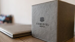 Un libro de cuero color gris con el texto "COMFOTEL HOTELS" en la portada.