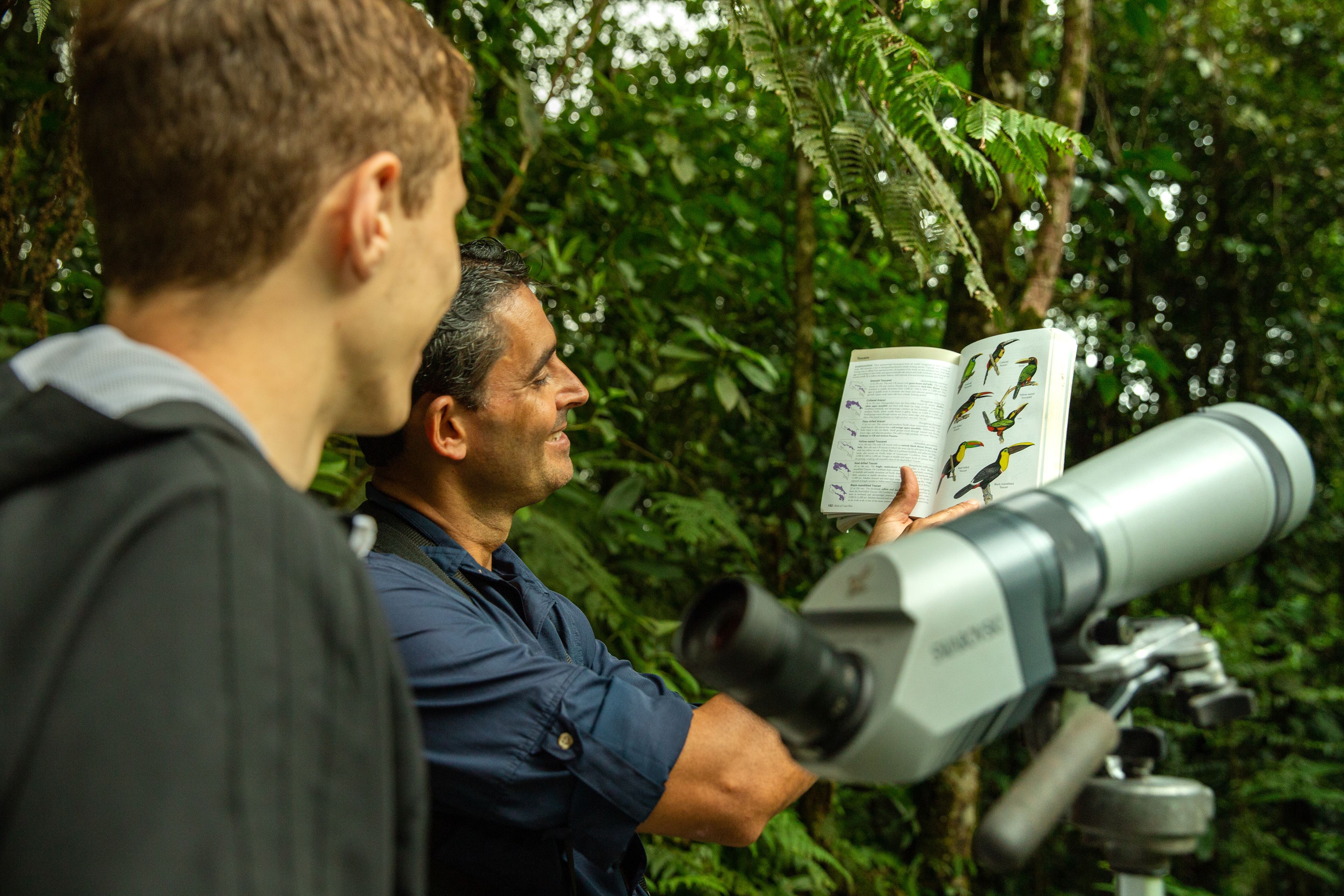 Une personne utilisant un télescope dans un environnement luxuriant et verdoyant.