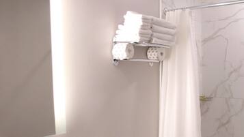 Un baño con lavamanos, espejo, tocador e inodoro.
