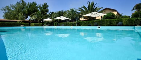 Piscine extérieure, parasols de plage, chaises longues