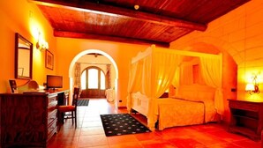 A room with a wooden ceiling, a bed with a canopy, a desk with a computer, and a view through an archway. - Tenuta San Francesco (Trinitapoli)