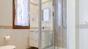 A modern bathroom with a glass shower enclosure, a toilet, and a sink. - Giulietta e Romeo (Verona)