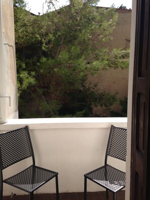Enjoy the serene view from this balcony with a tree in the background.