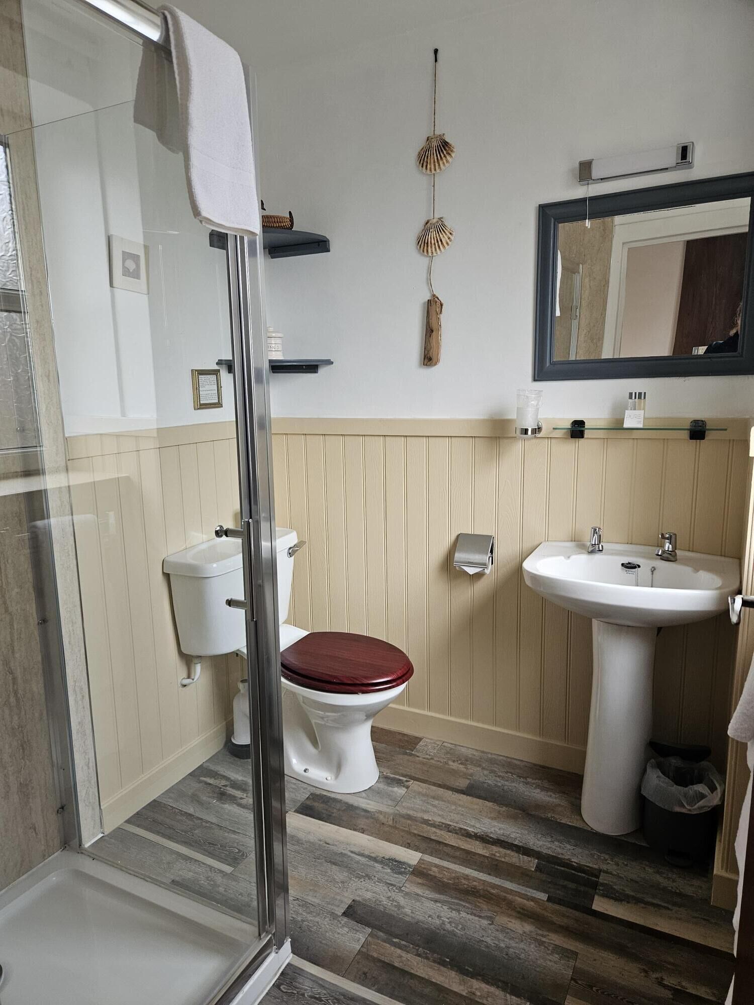 Een badkamer met toilet, wastafel en douchehoek.