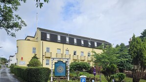 Een geel gebouw met een bord waarop 'Park Lodge Hotel' staat en een parkeersbord met de tekst 'Alleen Park Lodge'.