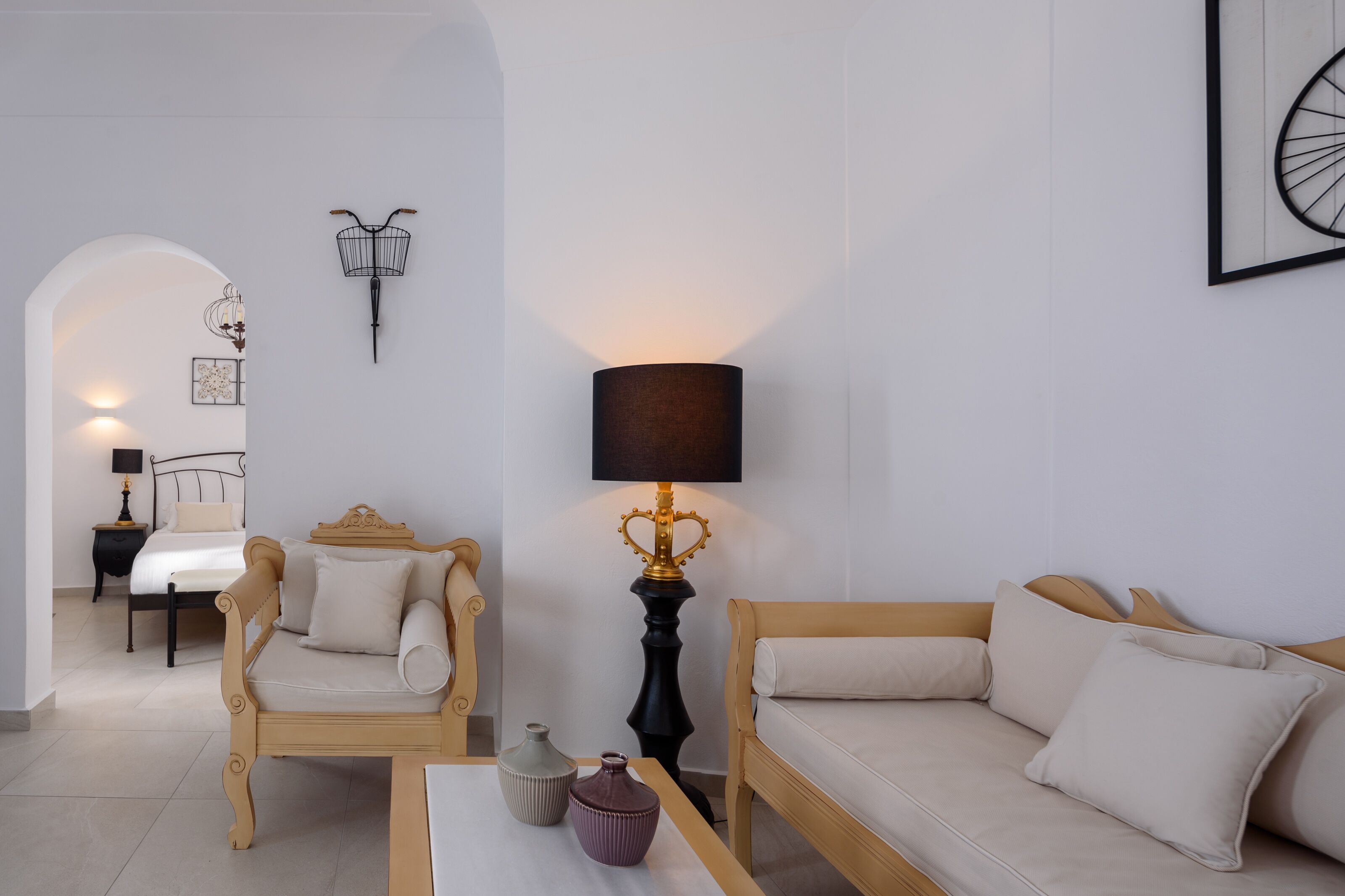 Un salon moderne avec un canapé, un fauteuil et une table agrémentée de vases décoratifs.