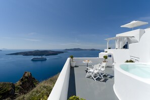 Un moderno edificio blanco con piscina, mobiliario exterior y vistas al mar y a las islas.