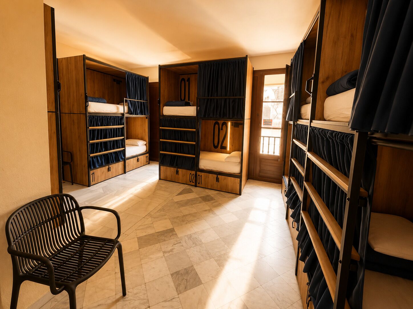 A room with bunk beds, a chair, and a door leading outside.