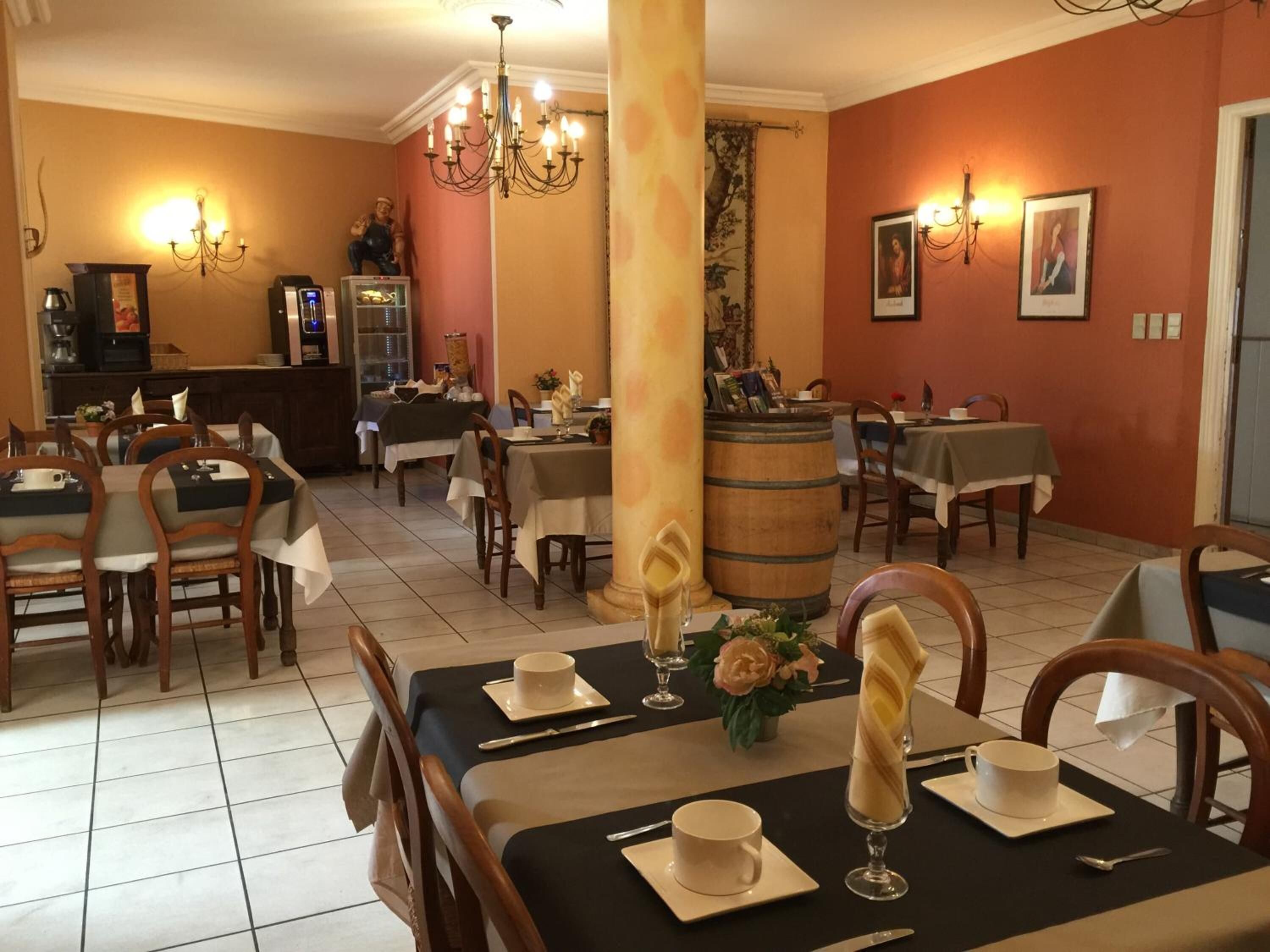 A restaurant with tables set for dining, a bar area, and a decorative column.