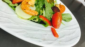Een bord garnetonsalade met sla, tomaten en andere groenten.