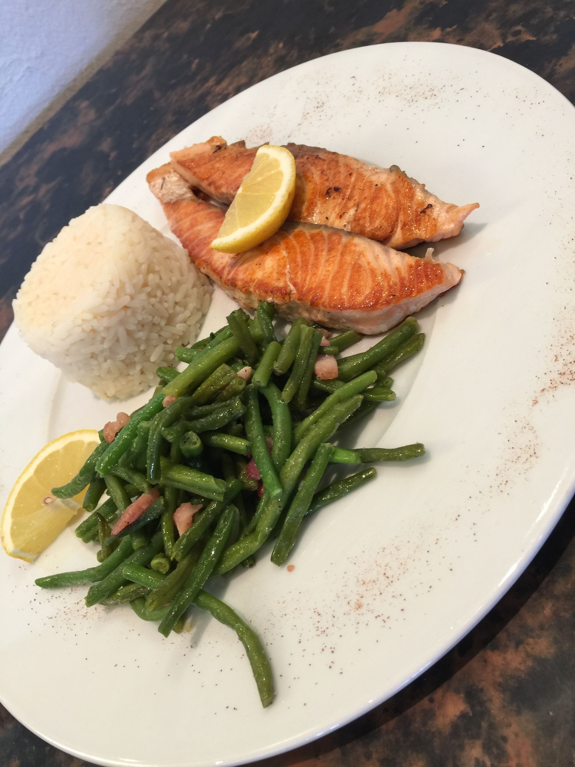 A plate with salmon, rice, and green beans.