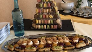 A tiered display of macarons and a tray of assorted pastries. - Le Roi Gourmand (Pamiers)